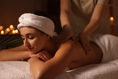 Photo of Young woman receiving massage in spa salon