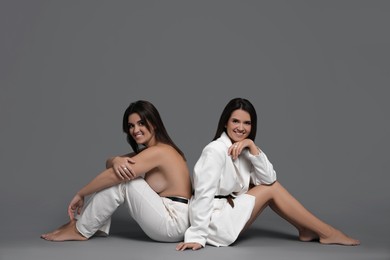 Photo of Portrait of beautiful twin sisters on grey background