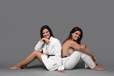 Photo of Portrait of beautiful twin sisters on grey background