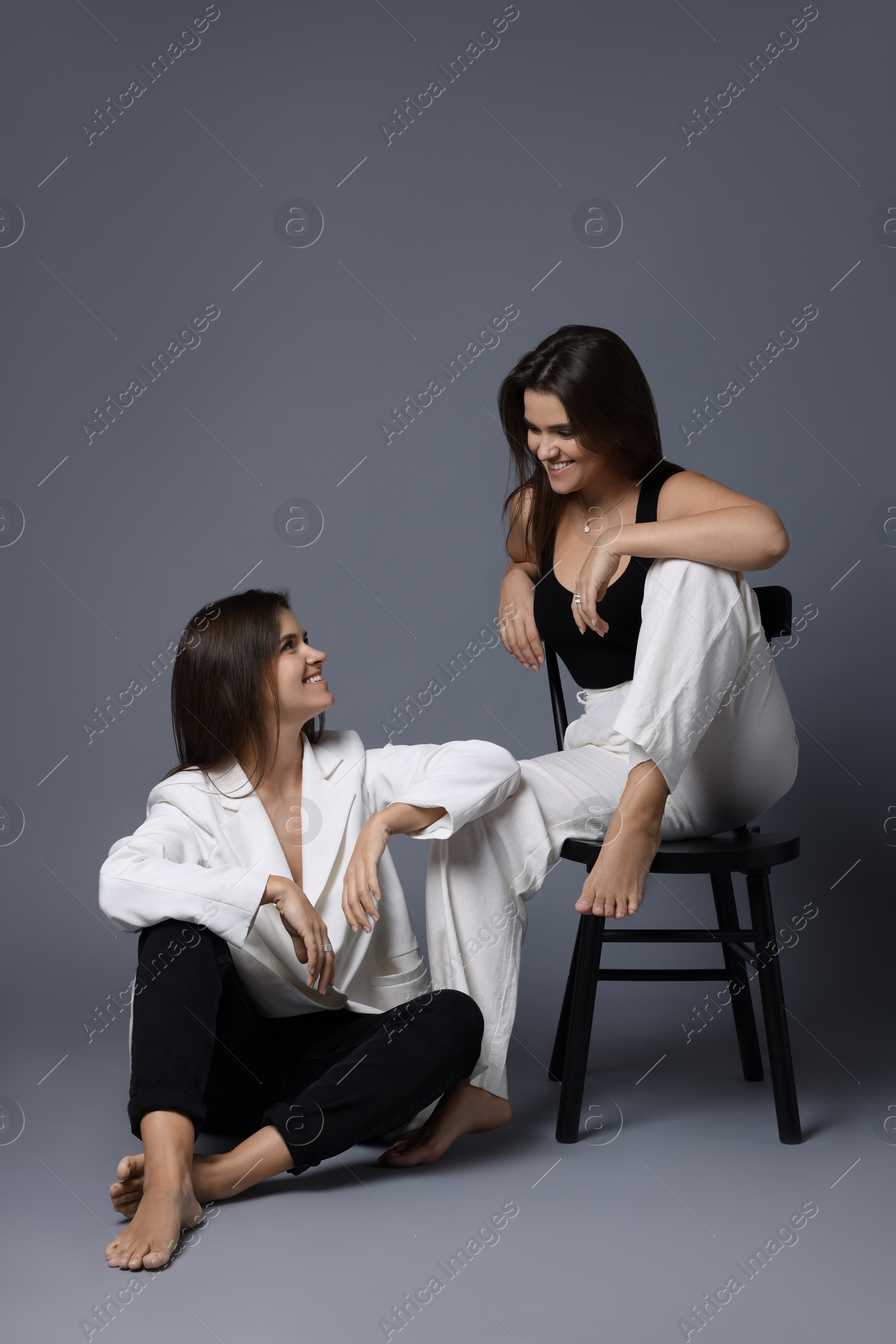 Photo of Portrait of beautiful twin sisters on grey background