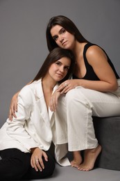 Photo of Portrait of beautiful twin sisters on grey background