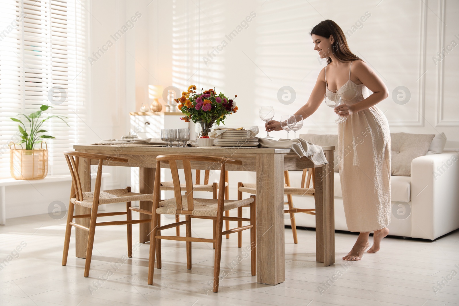 Photo of Woman setting table for dinner at home