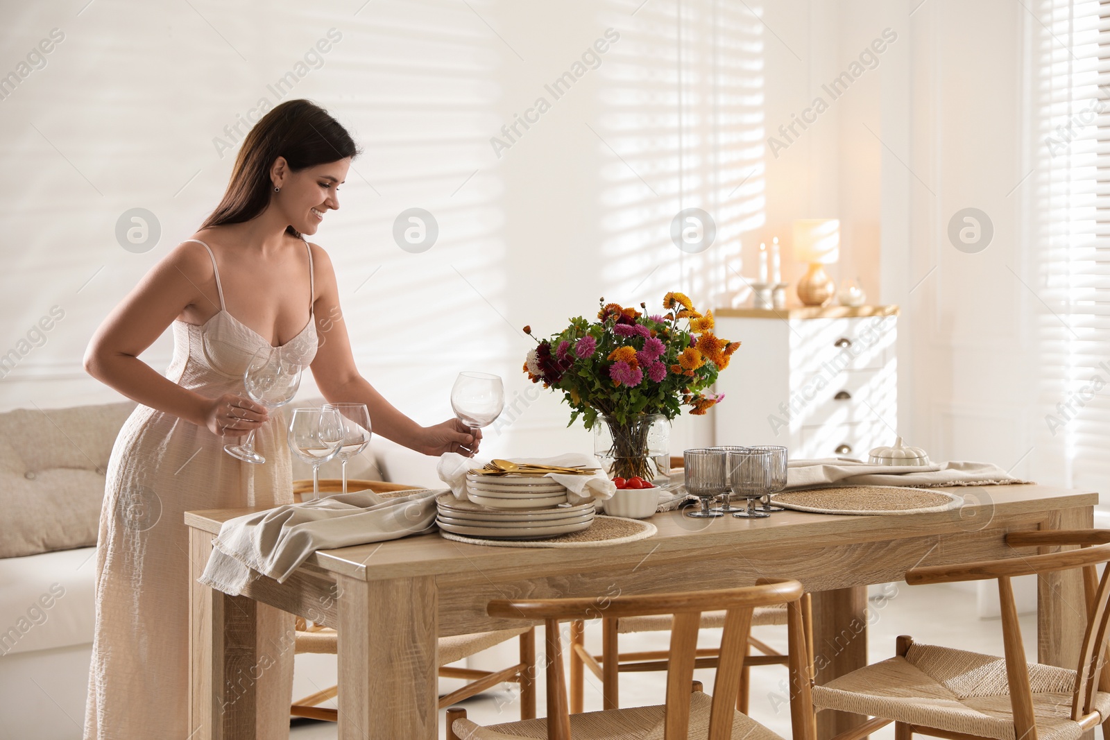 Photo of Woman setting table for dinner at home