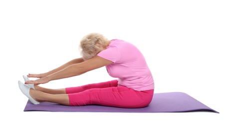 Photo of Senior woman exercising with fitness mat on white background