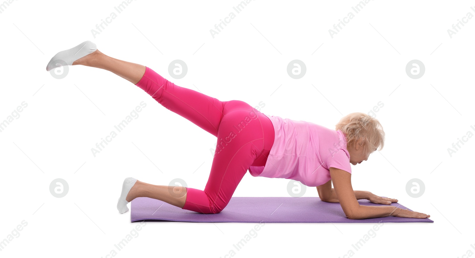 Photo of Senior woman exercising with fitness mat on white background