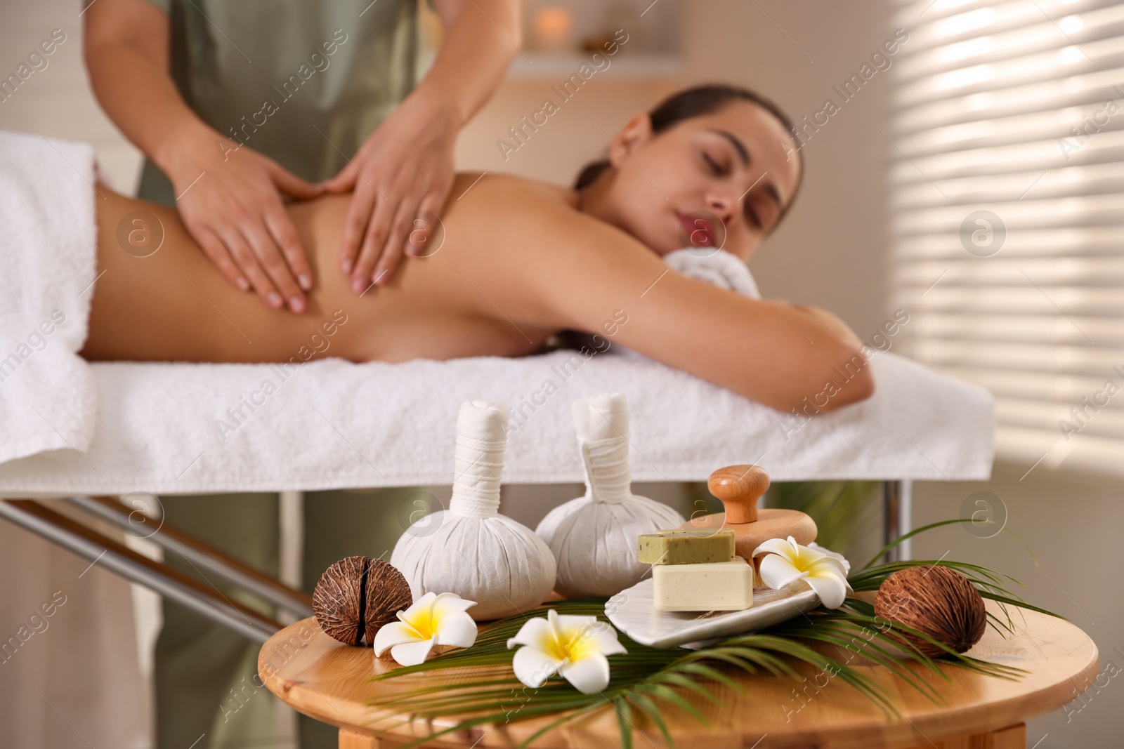 Photo of Woman receiving back massage in salon, focus on spa supplies