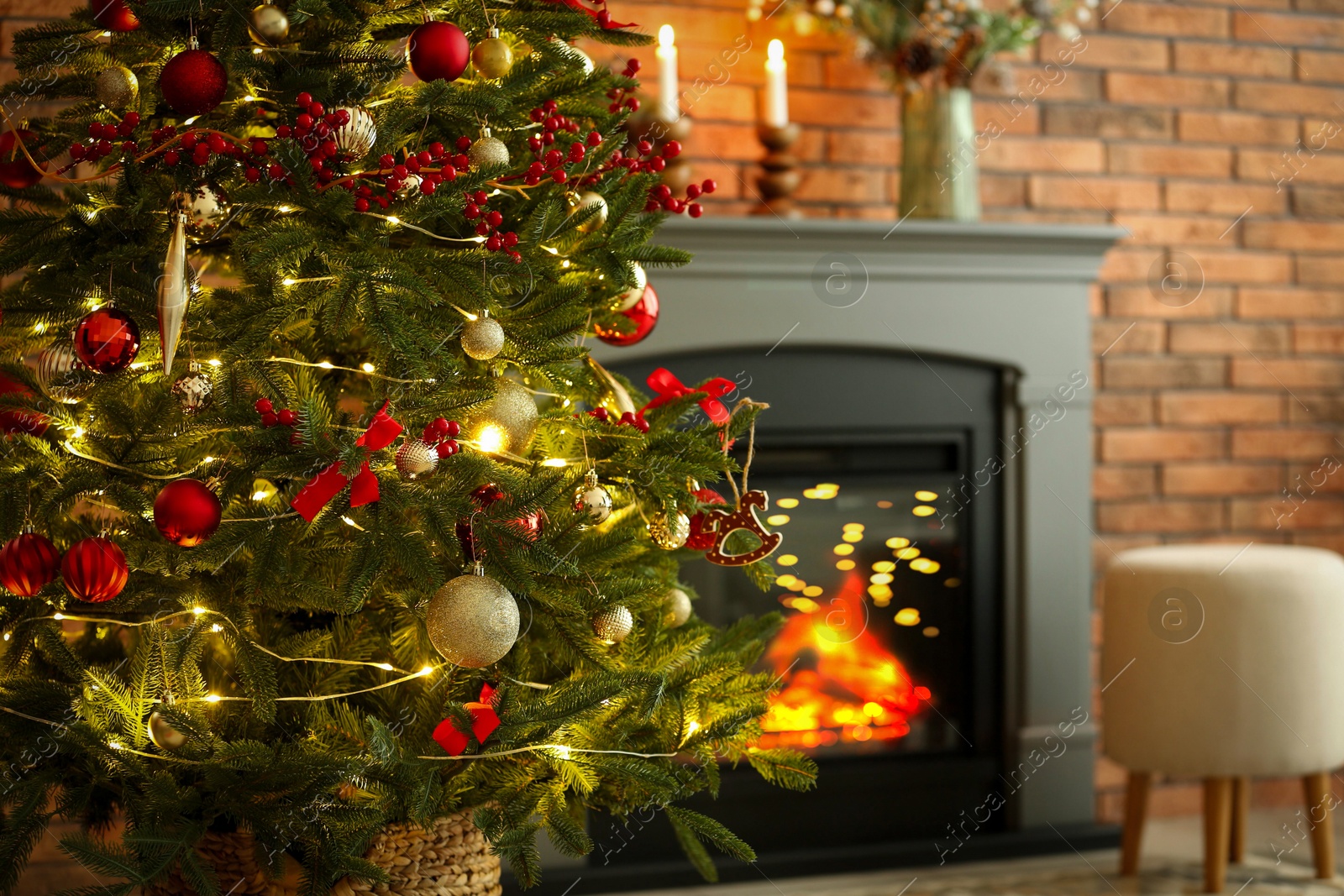 Photo of Beautiful decorated Christmas tree near fireplace at home, closeup. Space for text