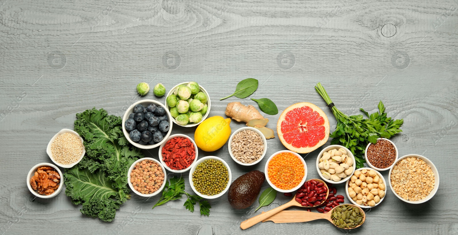 Photo of Superfood. Different healthy food products on grey wooden table, flat lay