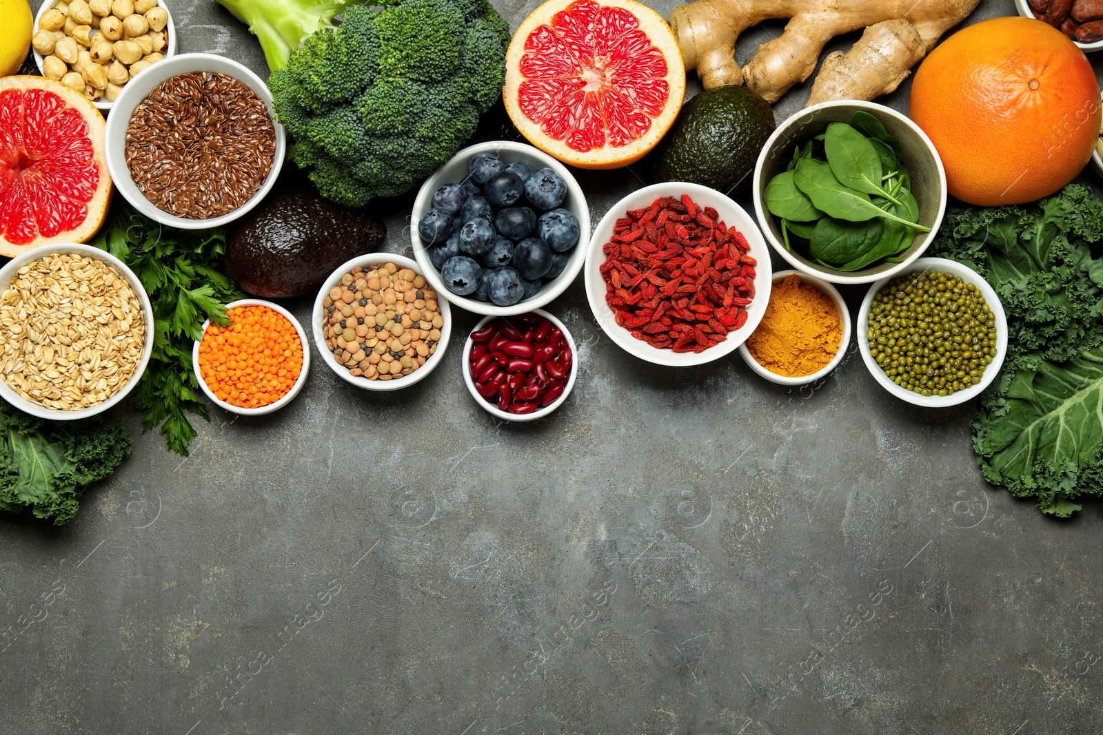 Photo of Superfood. Different healthy food products on grey table, flat lay. Space for text