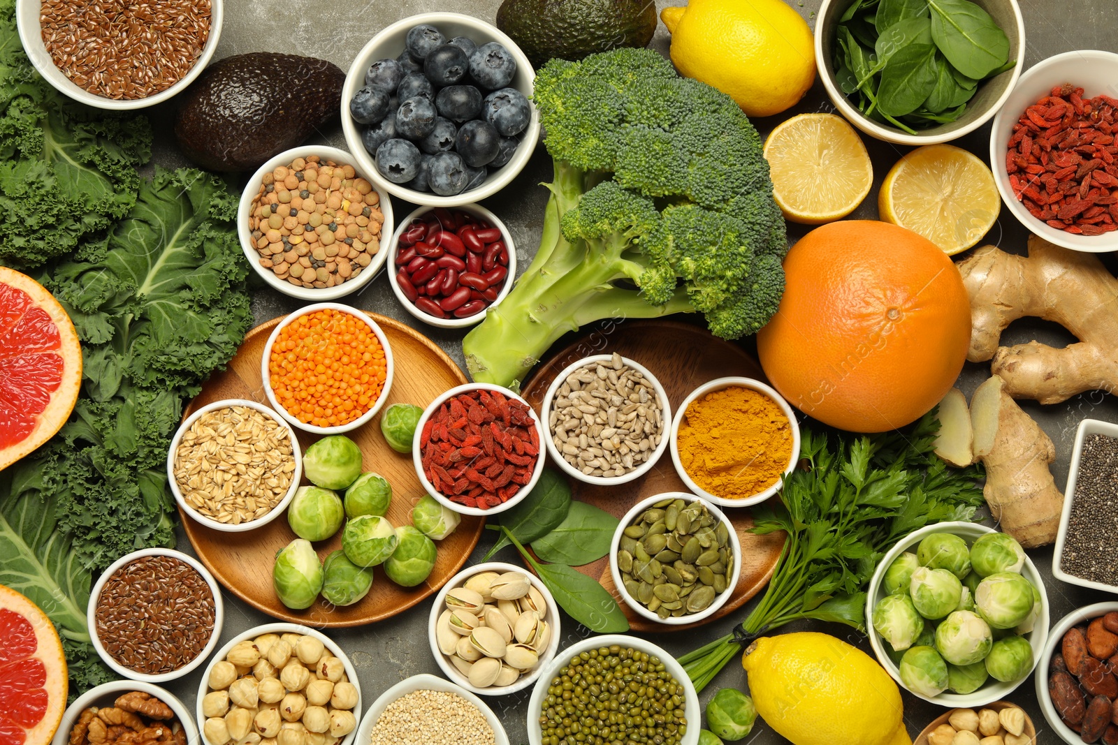 Photo of Superfood. Different healthy food products on grey table, flat lay