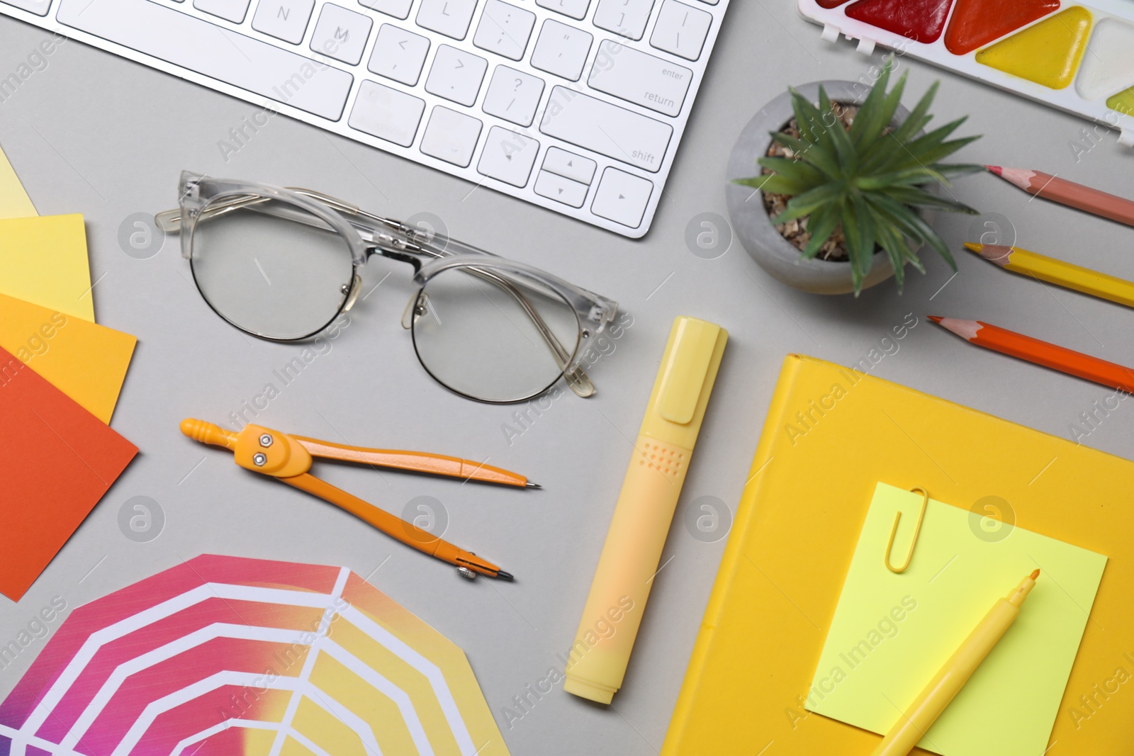 Photo of Designer's workplace. Flat lay composition with stationery and keyboard on light grey background