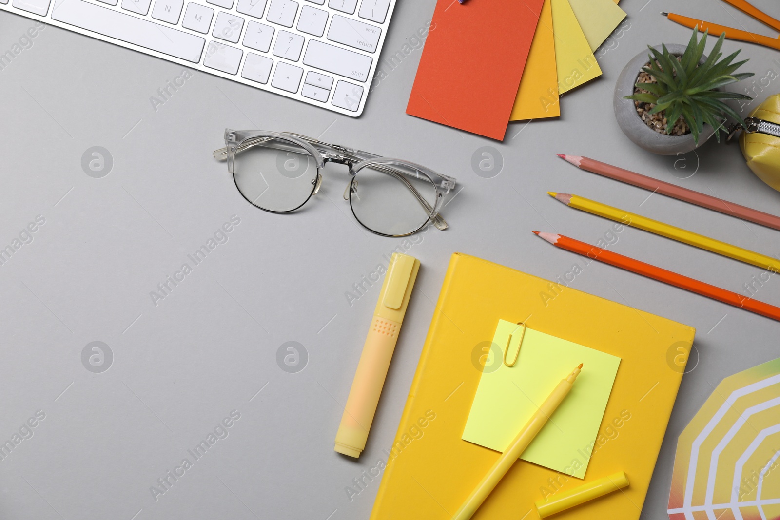 Photo of Designer's workplace. Flat lay composition with stationery and keyboard on light grey background, space for text