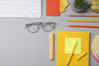 Photo of Designer's workplace. Flat lay composition with stationery and keyboard on light grey background, space for text