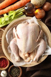 Photo of Fresh raw turkey in bowl and different products on table, flat lay