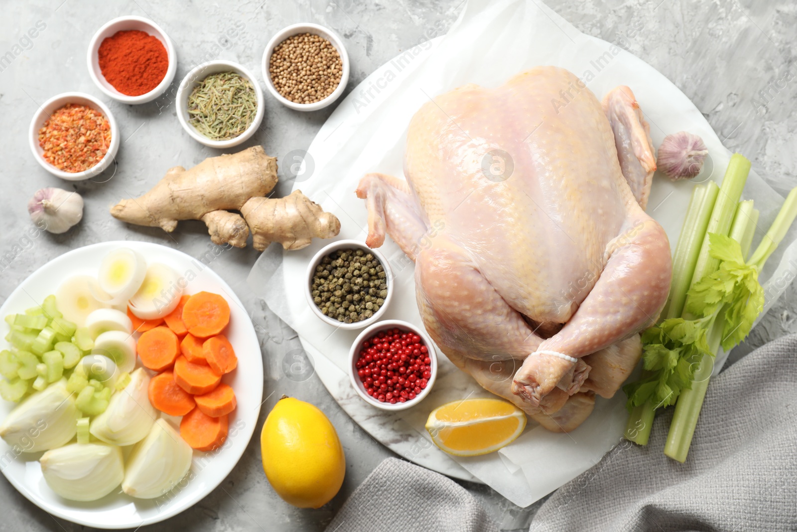 Photo of Fresh raw turkey and different products on gray textured table, flat lay