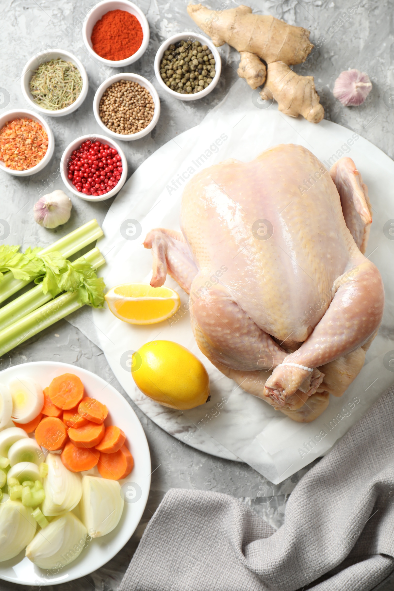 Photo of Fresh raw turkey and different products on gray textured table, flat lay