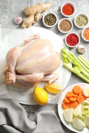 Photo of Fresh raw turkey and different products on gray textured table, flat lay