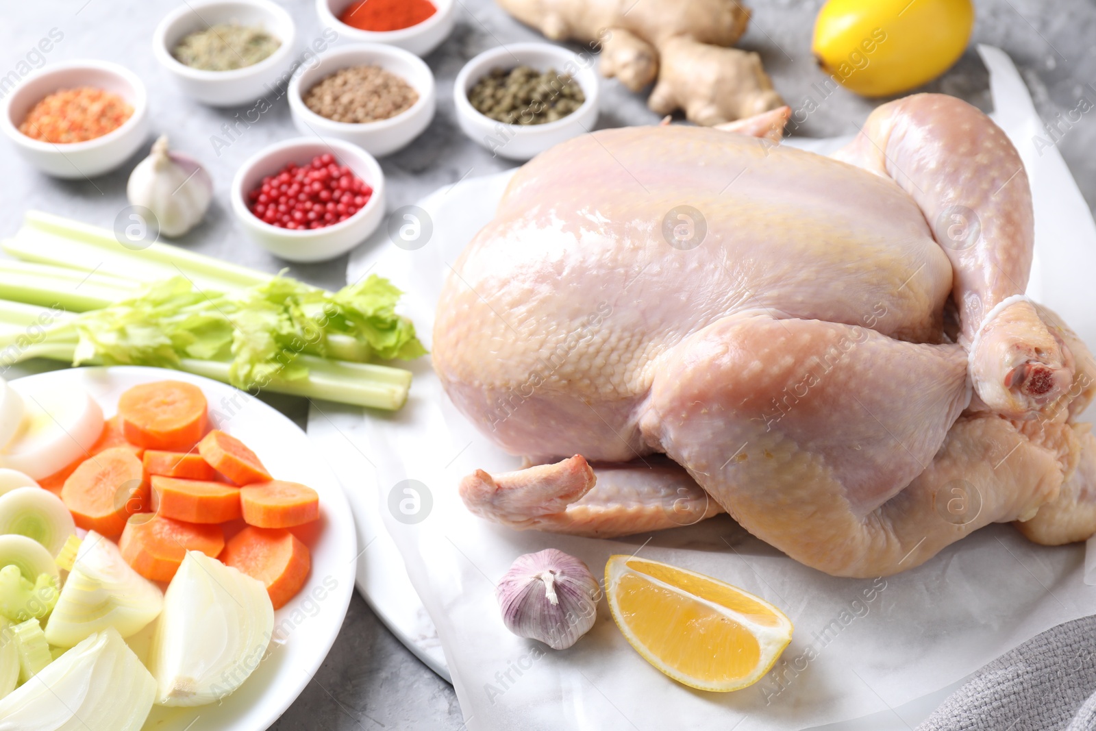 Photo of Fresh raw turkey and different products on gray textured table, closeup