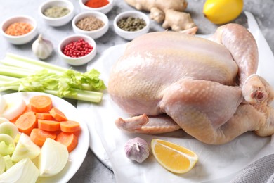 Photo of Fresh raw turkey and different products on gray textured table, closeup