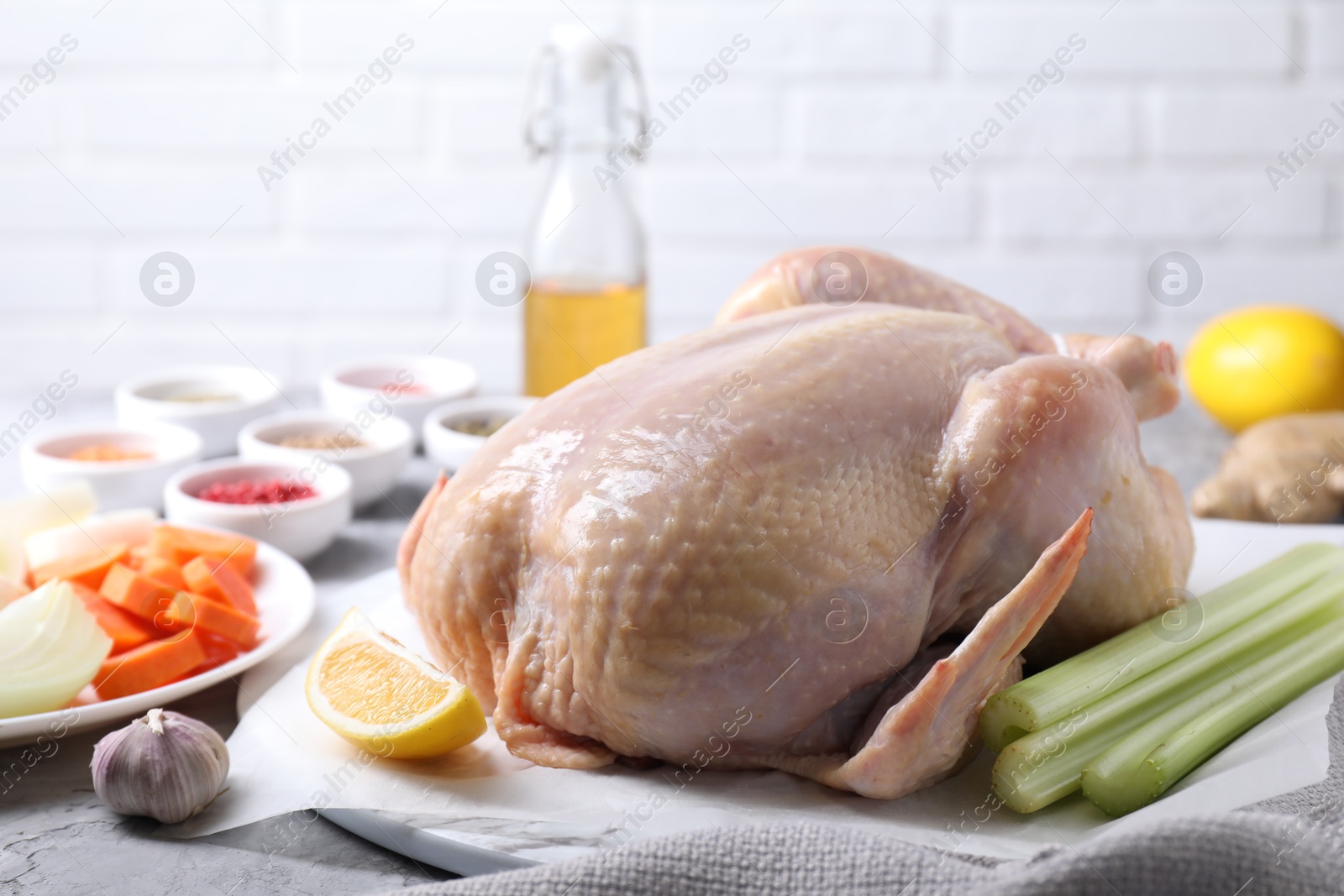 Photo of Fresh raw turkey and different products on gray textured table, closeup