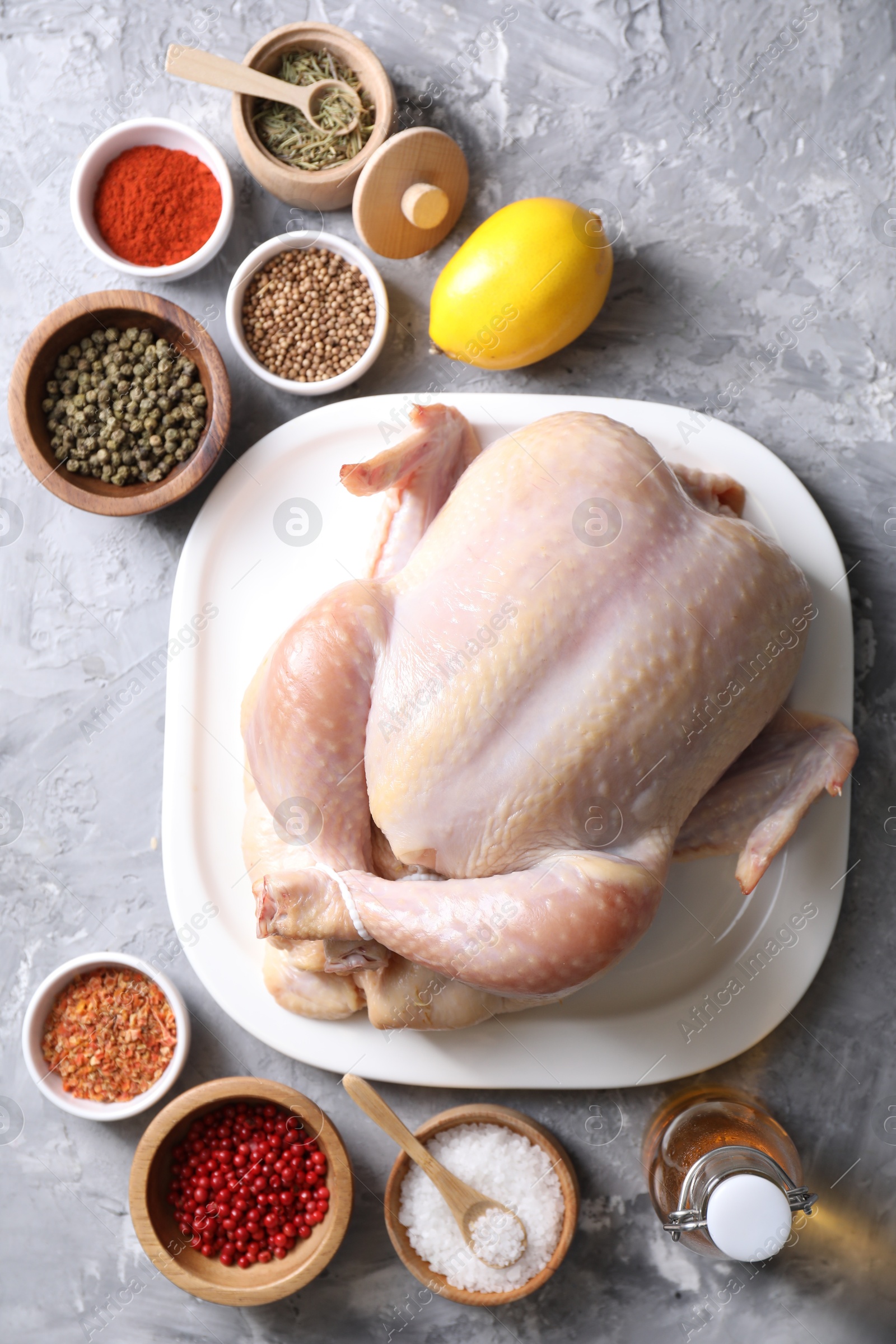 Photo of Fresh raw turkey and different products on gray textured table, flat lay