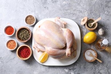 Photo of Fresh raw turkey and different products on gray textured table, flat lay