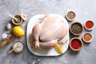 Photo of Fresh raw turkey and different products on gray textured table, flat lay