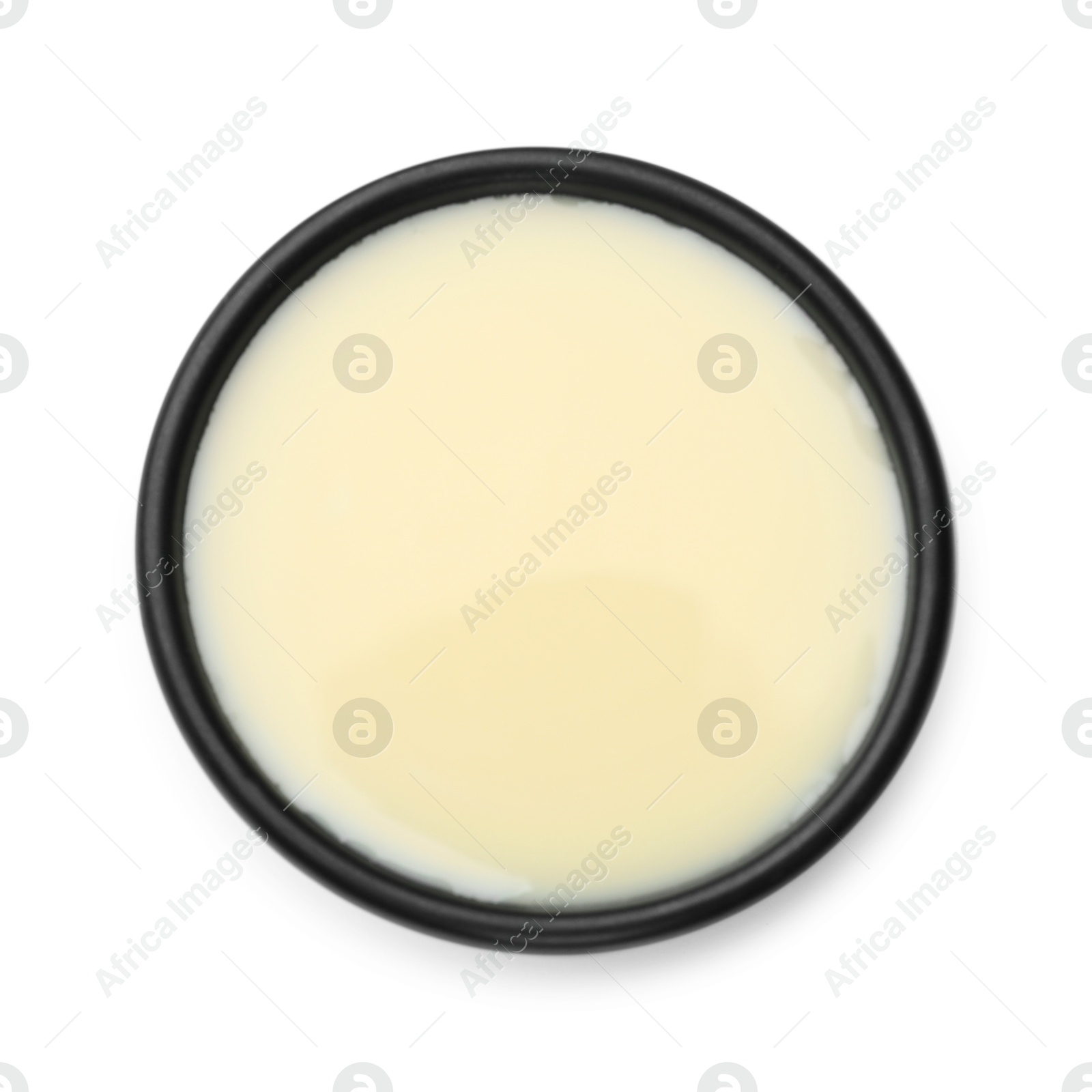 Photo of Condensed milk in bowl isolated on white, top view