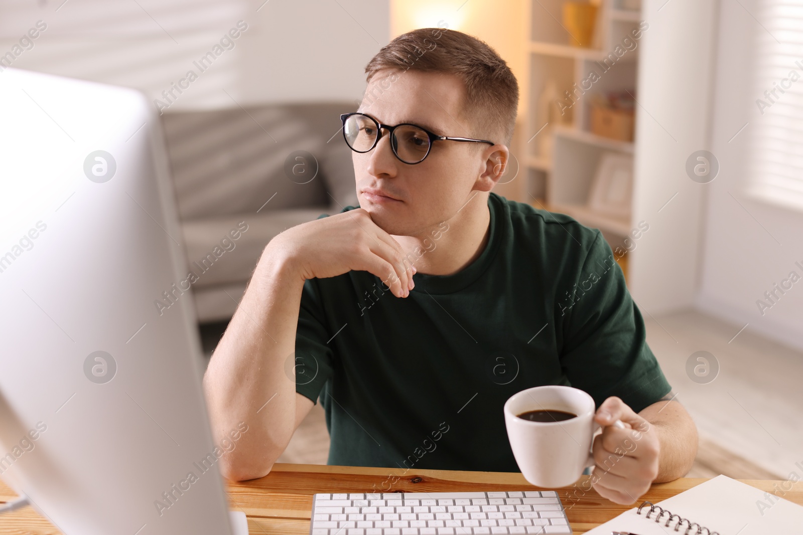 Photo of Handsome man working with computer at desk indoors. Home office