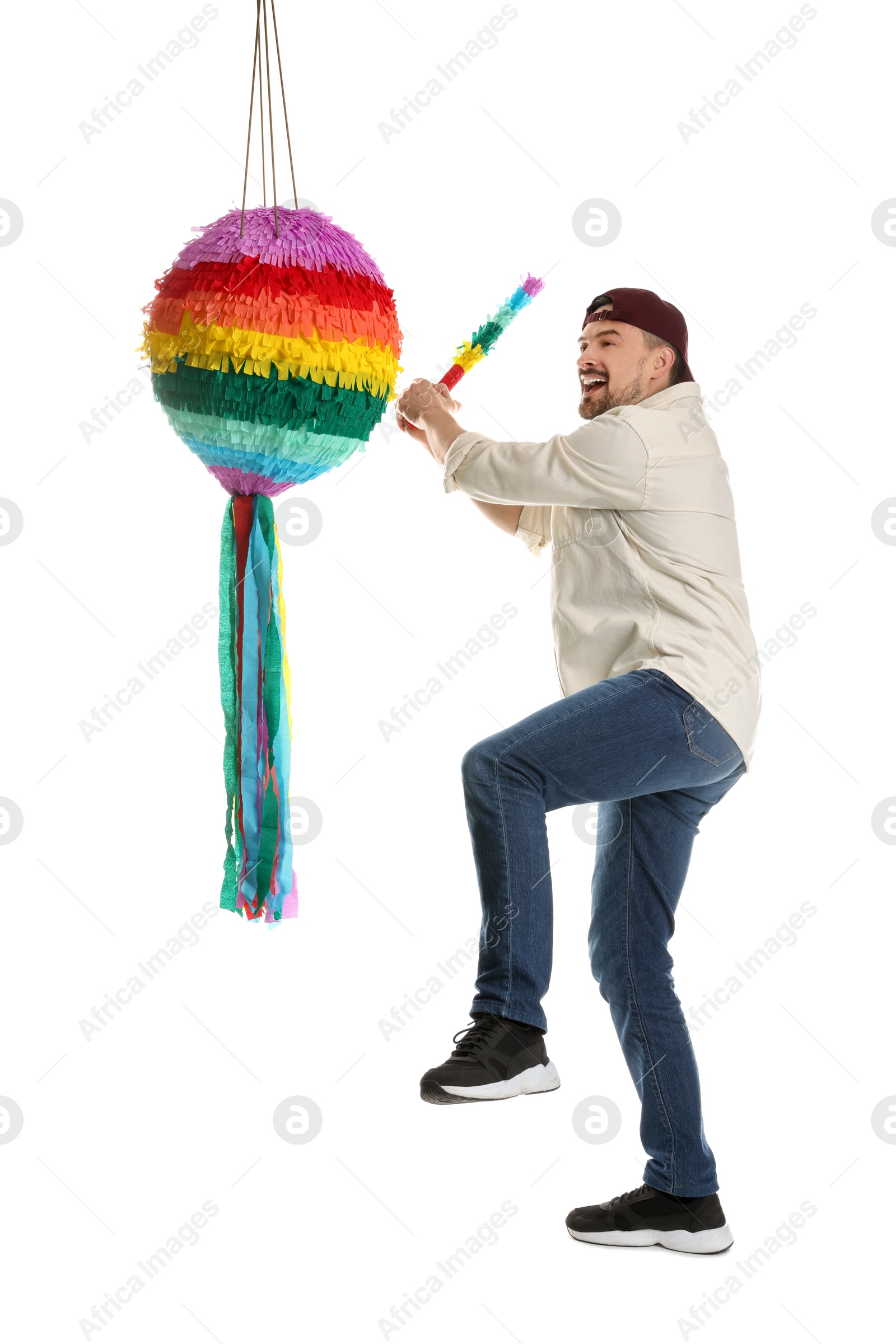 Photo of Emotional man hitting colorful pinata with stick on white background