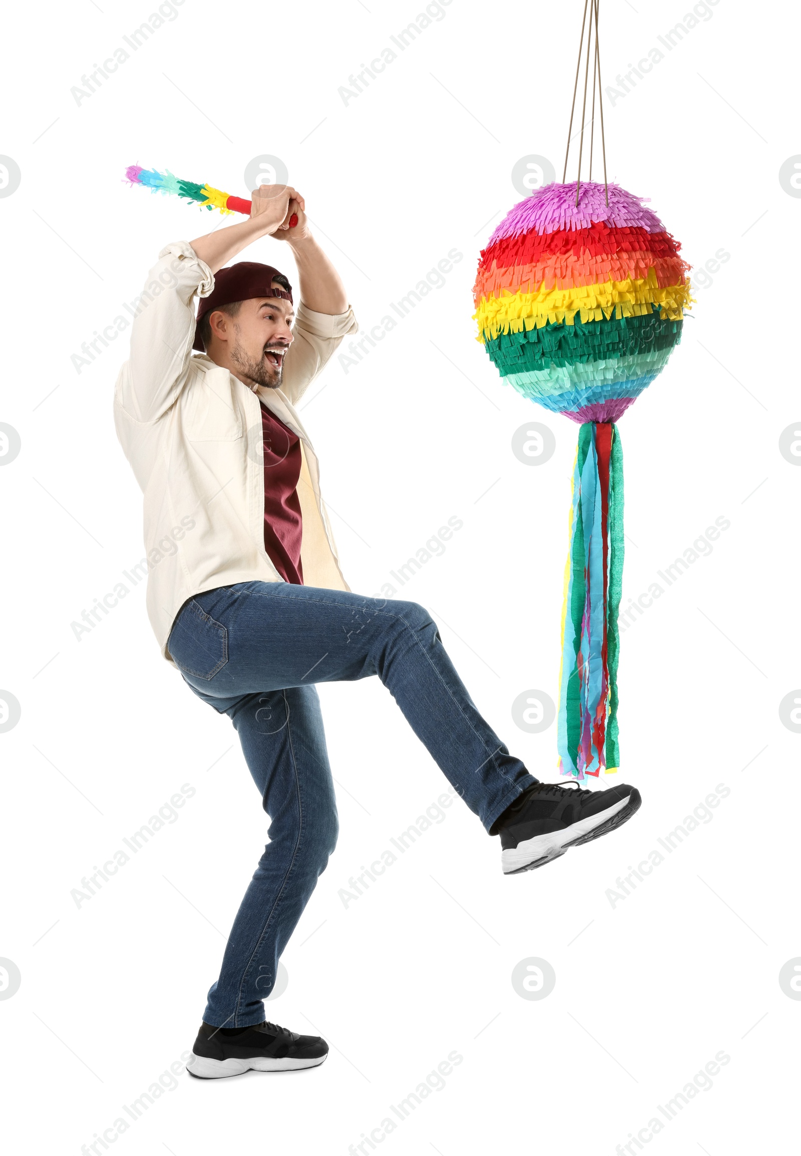 Photo of Emotional man hitting colorful pinata with stick on white background