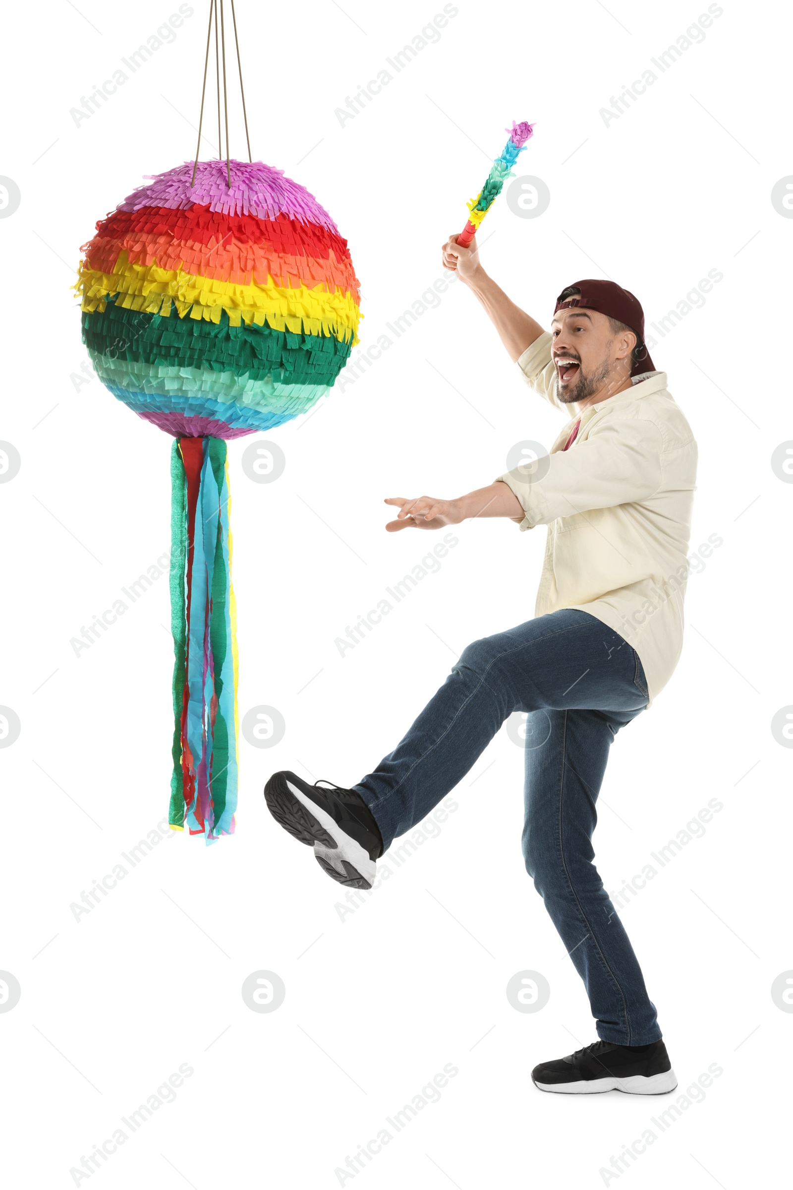 Photo of Emotional man hitting colorful pinata with stick on white background