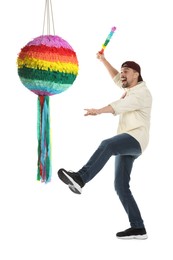 Photo of Emotional man hitting colorful pinata with stick on white background