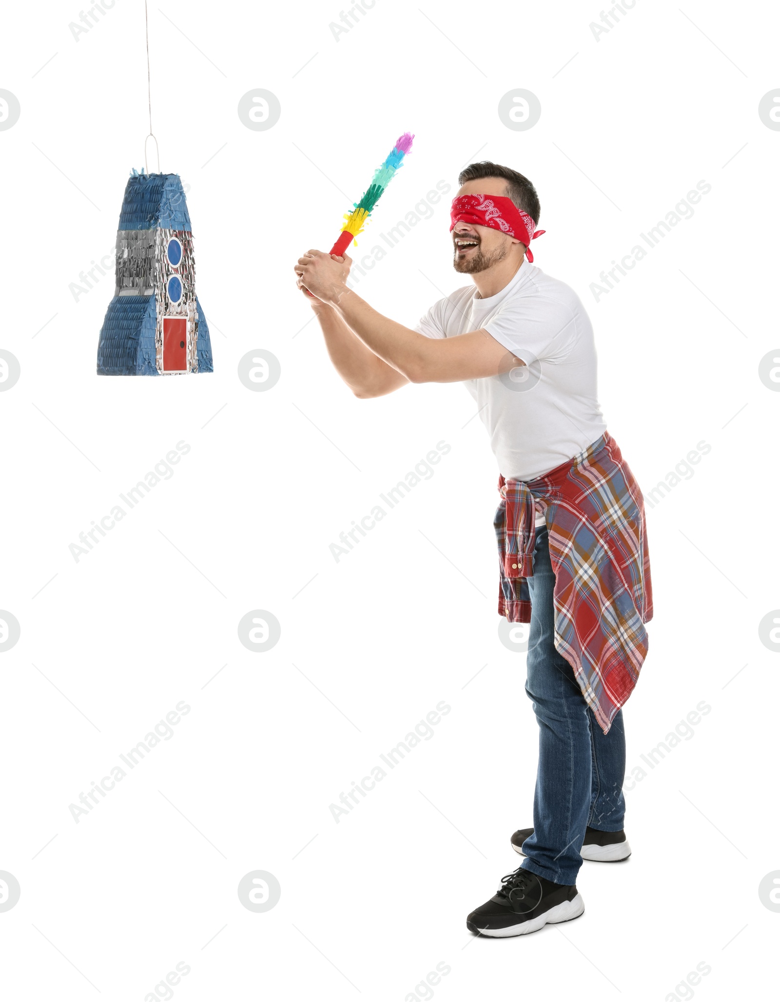 Photo of Blindfolded man hitting rocket shaped pinata with stick on white background