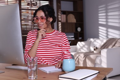 Photo of Beautiful woman working on computer at desk in home office