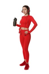 Photo of Woman in sportswear and headphones holding shaker on white background