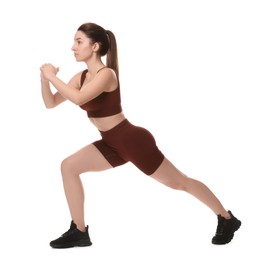 Woman in sportswear exercising on white background