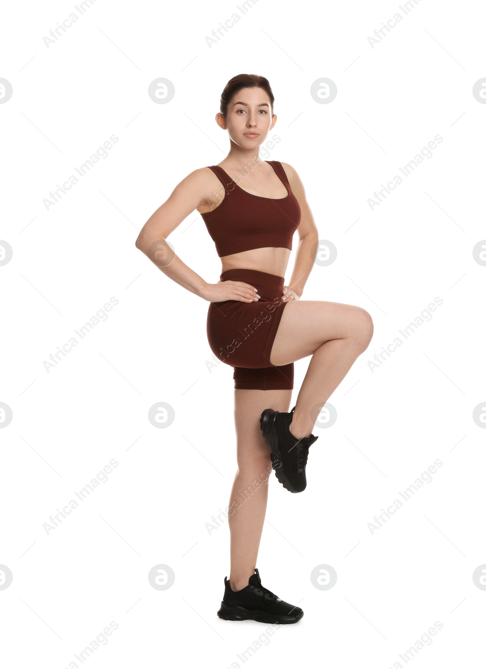 Photo of Woman in sportswear exercising on white background