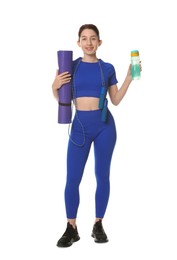 Woman in sportswear with fitness mat, bottle and skipping rope on white background