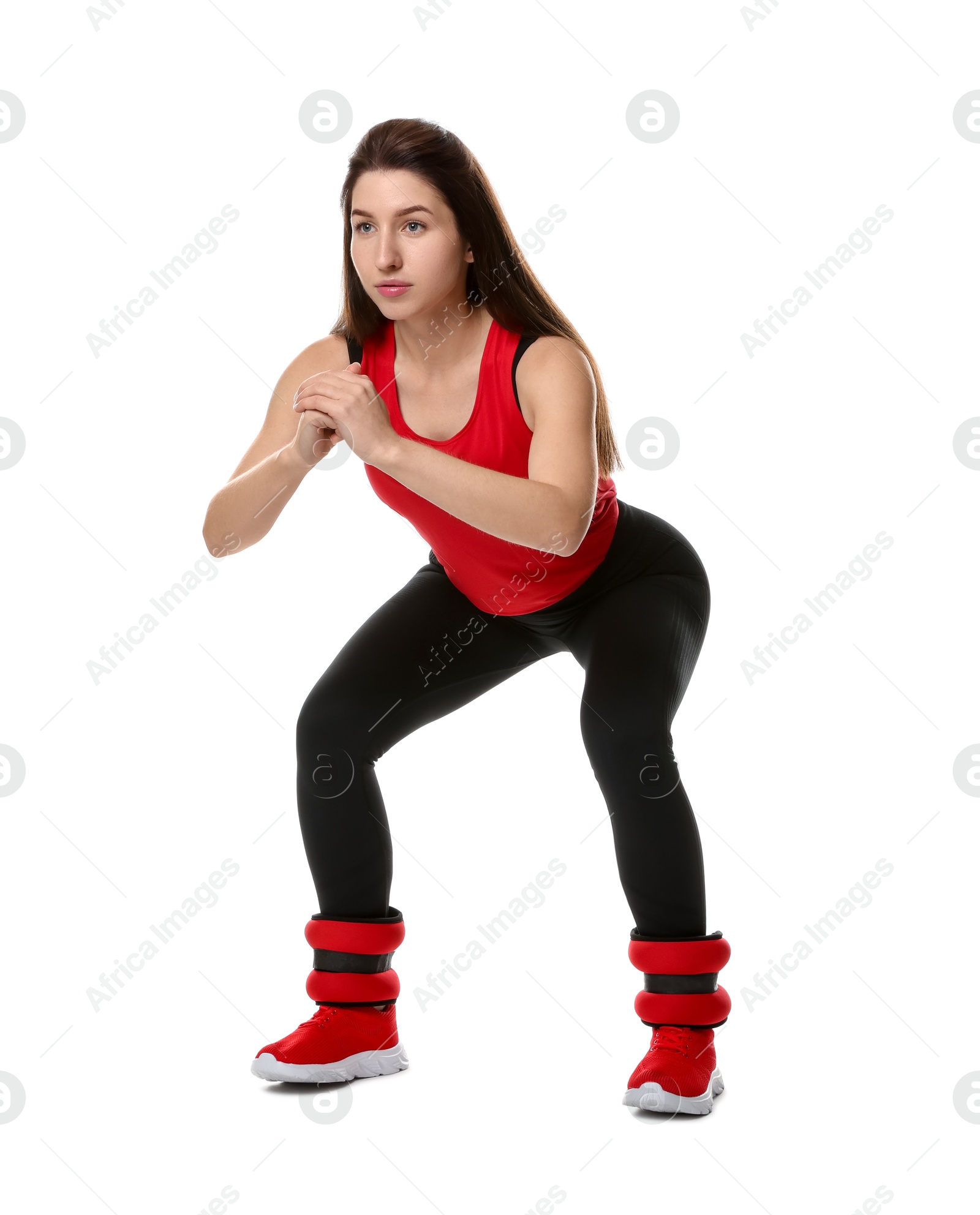 Photo of Woman in sportswear exercising with ankle weights on white background