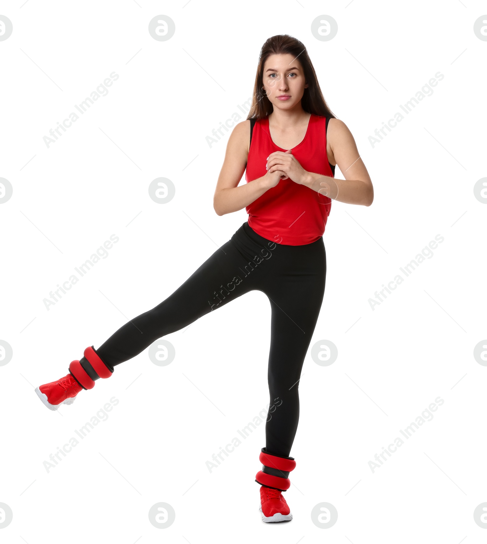 Photo of Woman in sportswear exercising with ankle weights on white background