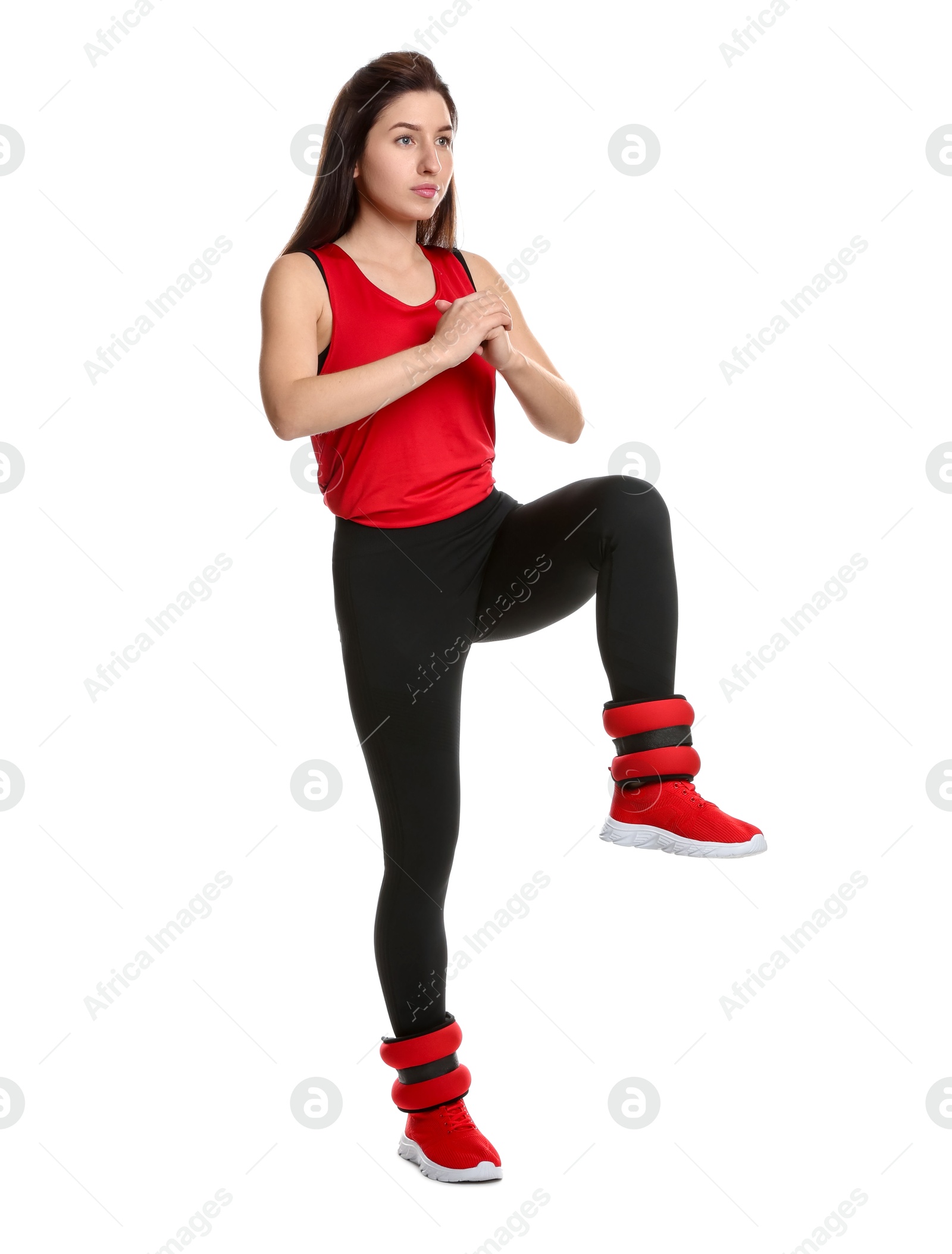 Photo of Woman in sportswear exercising with ankle weights on white background