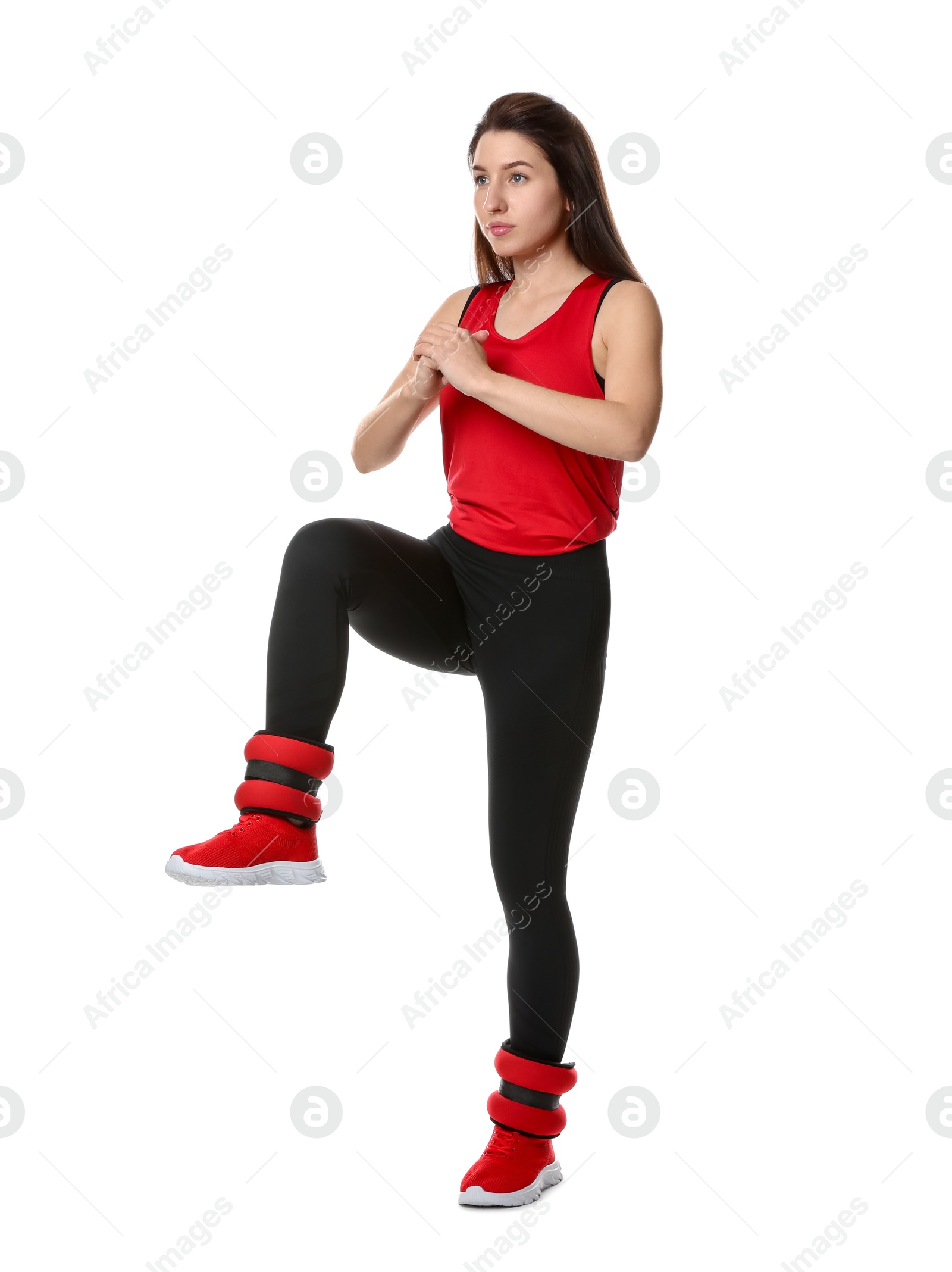 Photo of Woman in sportswear exercising with ankle weights on white background