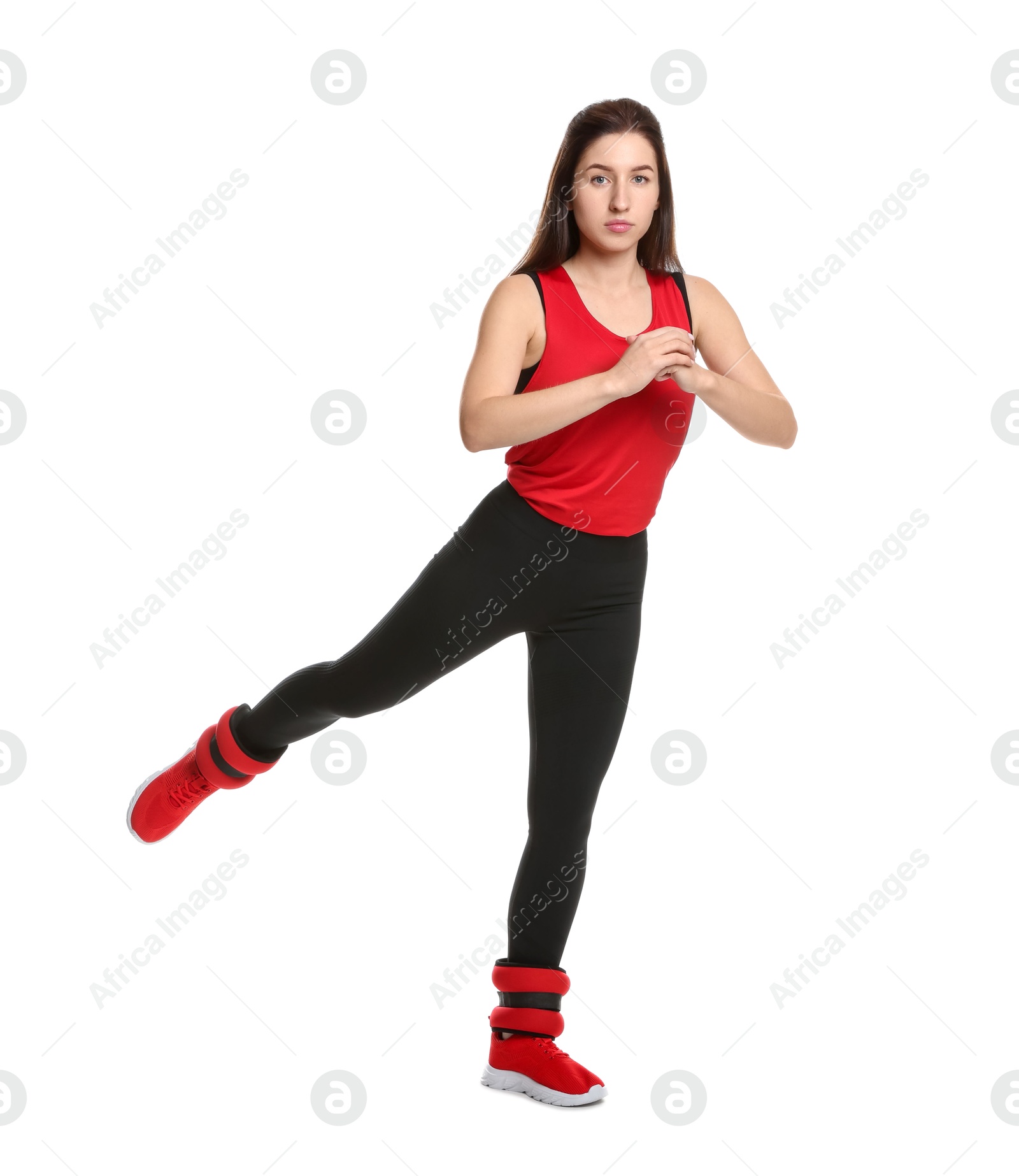 Photo of Woman in sportswear exercising with ankle weights on white background