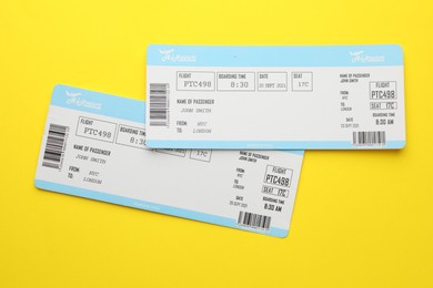 Photo of Travel agency. Flight tickets on yellow background, top view