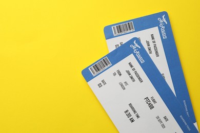 Photo of Travel agency. Flight tickets on yellow background, top view. Space for text