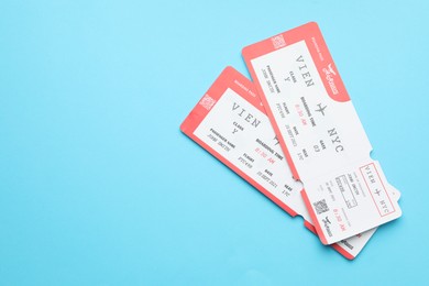 Photo of Travel agency. Flight tickets on light blue background, top view. Space for text