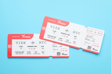 Photo of Travel agency. Flight tickets on light blue background, top view