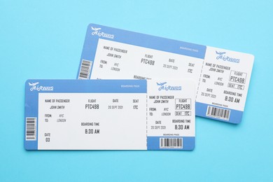 Photo of Travel agency. Flight tickets on light blue background, top view