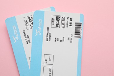 Photo of Travel agency. Flight tickets on pink background, top view